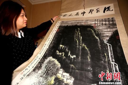 图为汪女士展示《流水声中有人家》山水画作。杨正华摄