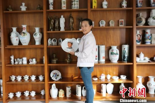 图为农家乐负责人林巧霞展示毛主席瓷像章。　王陆斌　摄  图为新疆博湖县一农家乐收藏的伟人挂图。　王陆斌　摄