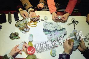 翡翠爱好者围观一块翡翠大料雕刻件，赏析过程中，不断有惊叹之声。