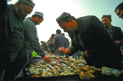 玉龙喀什河边的洛浦县，来总分水闸口旁玉石巴扎（玉石集市）的人分三种：一是在河边拣玉或挖玉者，二是当地农民变成的专业商贩，三是专程来大批收购的外地专业玉器商，熙熙攘攘的玉石交易摊延伸了半公里。